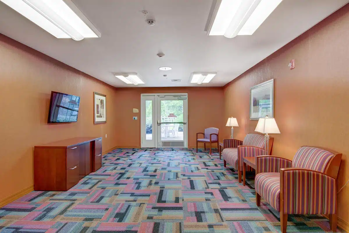 A room with a TV and couches at Willoughby Post Acute